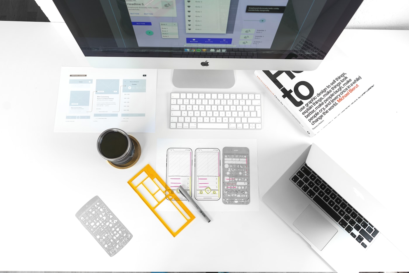Top-down view of a bright designer's desk with keyboard, notebook and devices
